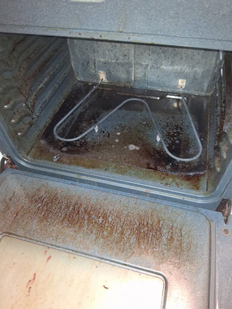 An extremely greasy and grimy oven interior, illustrating a challenging before-cleaning scenario for CleanSlate Cleaning Company in Lansing, MI.