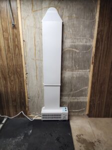 An EZ Breathe ventilation system installed in a wood-paneled basement by EverDry Toledo in Toledo, OH.