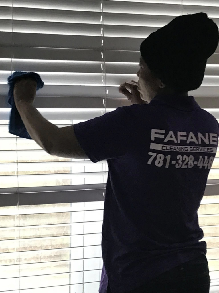 A Fafane Cleaning Services professional meticulously wiping window blinds during a house cleaning in Boston, MA.
