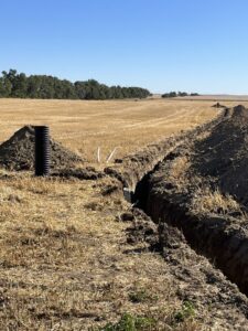 Field drainage and water pipe installation in a trench by KD Services - Excavating in Bismarck, ND