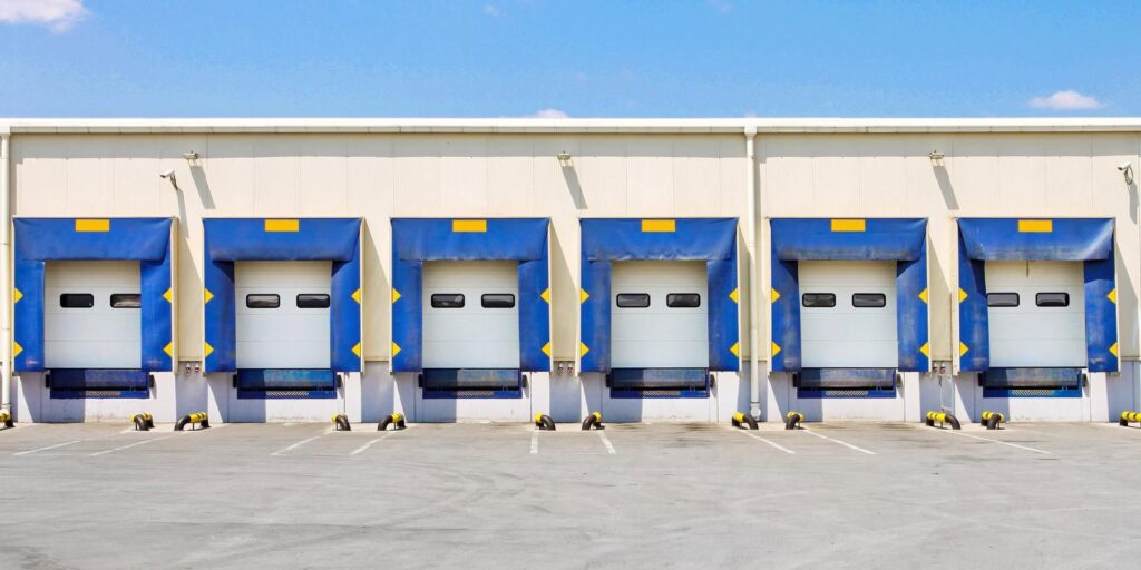 Five commercial loading dock doors at a business facility serviced by Pioneer Overhead Door, Inc in Las Vegas, NV.