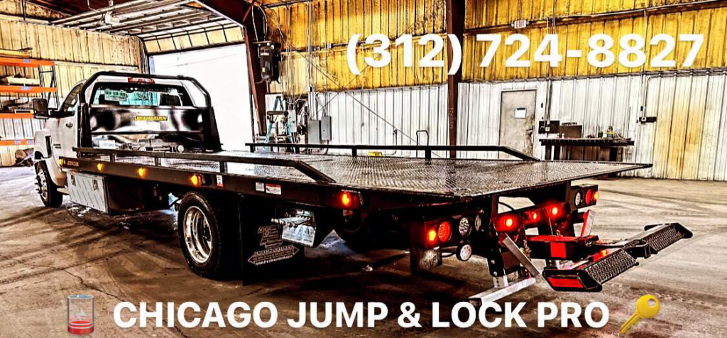 A flatbed tow truck from Chicago Jump & Lock Pro inside a garage in Chicago, IL, ready for vehicle transport.