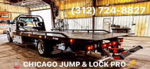 A flatbed tow truck from Chicago Jump & Lock Pro inside a garage in Chicago, IL, ready for vehicle transport.