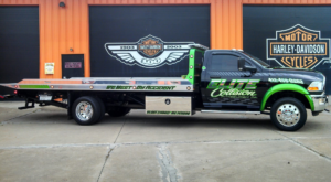 A green and black flatbed tow truck from Elite Collision, ready for towing services in Pittsburgh, PA.