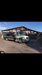 A flatbed tow truck transporting a black SUV for Rice Lake Collision in Duluth, MN.