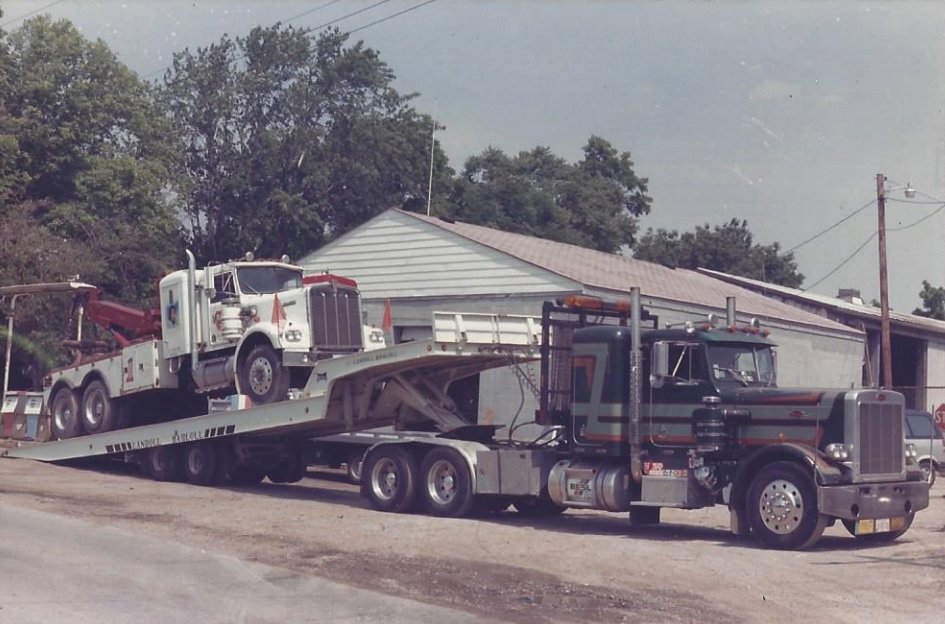 An old photo of a Bevis Towing flatbed truck towing another tow truck in Cincinnati, OH.