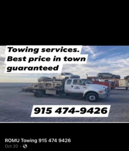 A flatbed tow truck from ROMU Towing in El Paso, TX, with a car loaded on its bed.