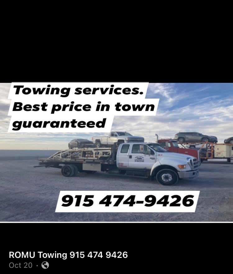 A flatbed tow truck from ROMU Towing in El Paso, TX, with a car loaded on its bed.