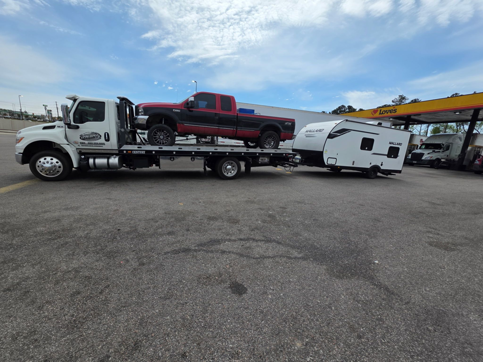 Flatbed tow truck transporting a pickup truck and travel trailer for County Towing & Recovery LLC in West Columbia, SC.