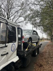 A white flatbed tow truck from Andre's Towing Services, LLC transporting a silver SUV in Marietta, GA.
