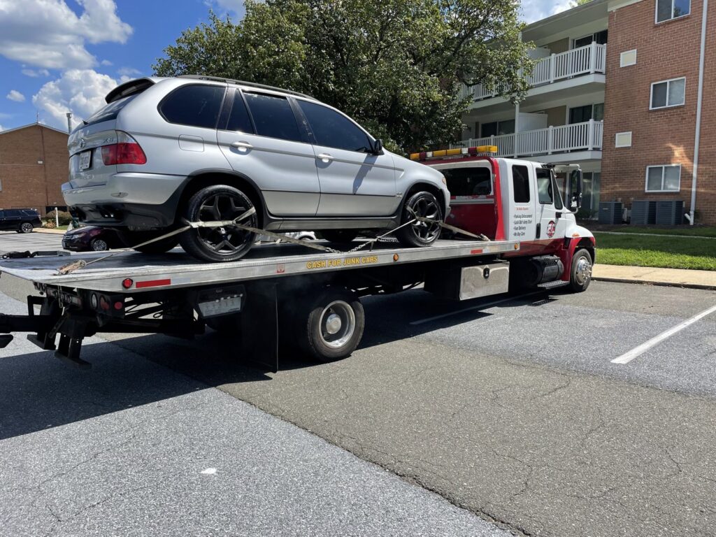 An E.C. Towing, Inc. flatbed tow truck transporting a silver SUV in Gaithersburg, MD.