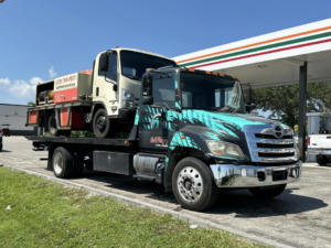 A flatbed tow truck from Always Ready Towing transporting a smaller truck in North Fort Myers, FL.