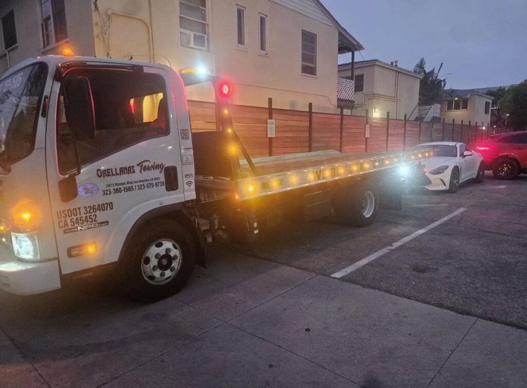 Orellanas Towing & Junk Car flatbed tow truck with its bed lowered, ready for a towing service in Los Angeles, CA.