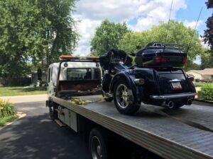 A&W Towing and Repair flatbed tow truck transporting a black trike motorcycle in Appleton, WI.
