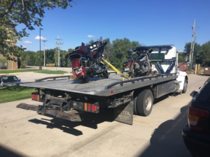 A flatbed tow truck transporting two motorcycles for Lone Tree Towing in Grand Island, NE.