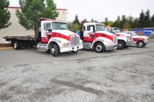 A fleet of Al's Towing flatbed and wrecker trucks parked in Jackson, NJ