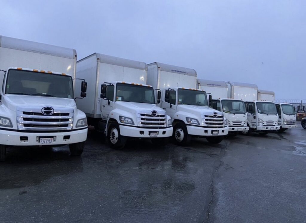 A fleet of IMoving Professional Moving System Inc. moving trucks lined up in San Francisco, CA