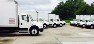A fleet of white moving trucks parked and ready for service at Empire Express Transport in Cincinnati, OH.