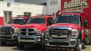 A fleet of red tow trucks parked outside Bobby's TCB Towing business in Detroit, MI