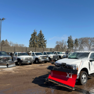 A fleet of snow plow trucks ready for service at Ceres Mulch in Brooklyn Park, MN