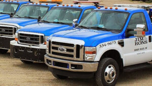 A fleet of white and blue tow trucks from Jim & Ron's Service Inc. lined up in Sioux Falls, SD.