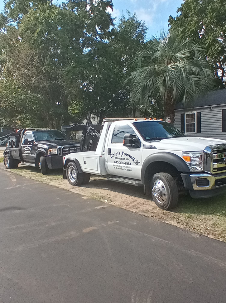 A fleet of white and black tow trucks parked, ready for service, from Towing services in North Charleston, SC.