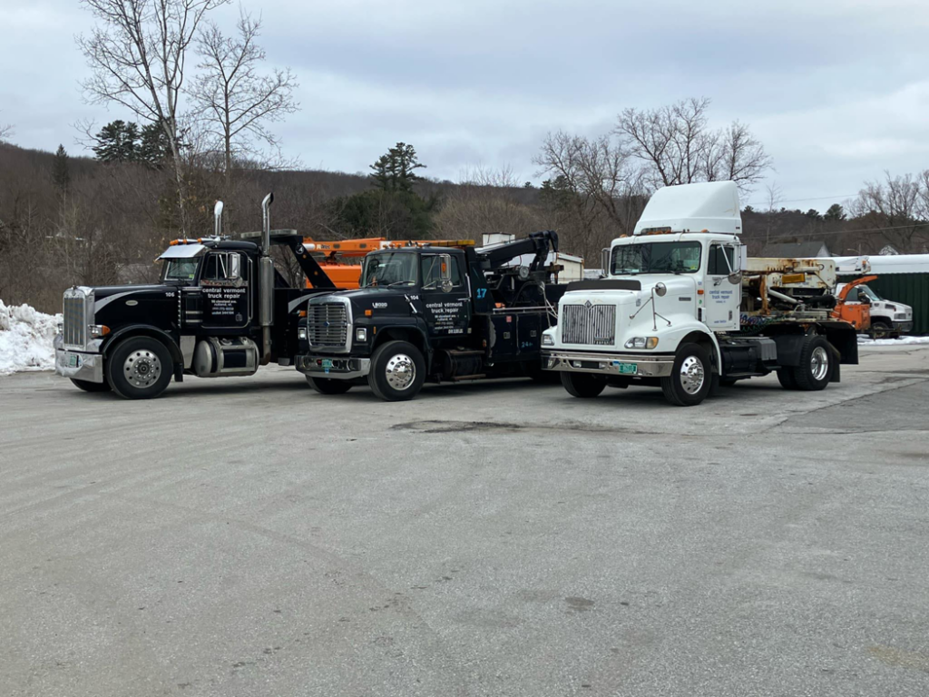 A fleet of professional tow trucks ready for service at Vermont Towing Association in Brownington Village, VT.