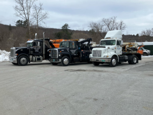 A fleet of professional tow trucks ready for service at Vermont Towing Association in Brownington Village, VT.