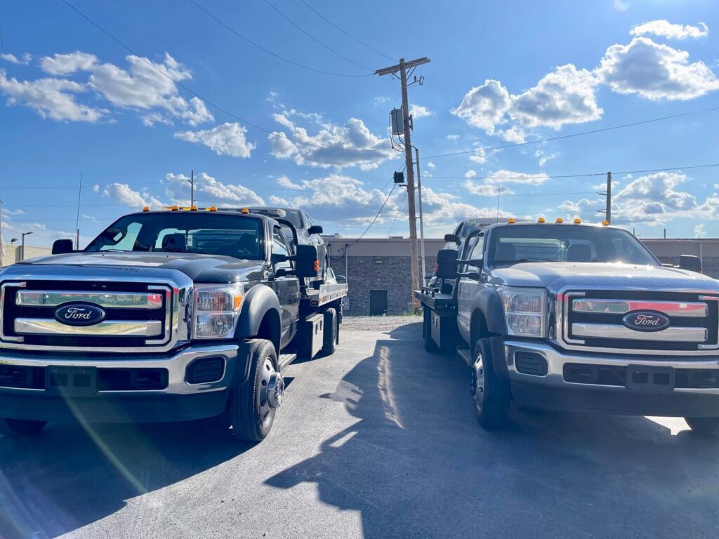 A fleet of FE Transportation LLC tow trucks with cars on their flatbeds in Cincinnati, OH.