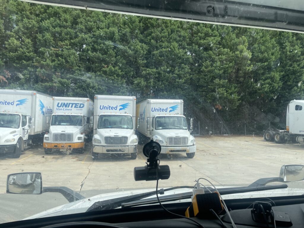 A fleet of United moving trucks parked in a lot, representing The Armstrong Company in Huntsville, AL.