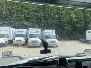 A fleet of United moving trucks parked in a lot, representing The Armstrong Company in Huntsville, AL.