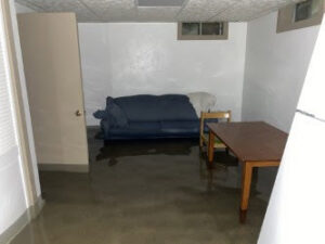A room with standing water on the floor, indicating significant water damage requiring restoration by Flow State Restoration in Gilbert, AZ