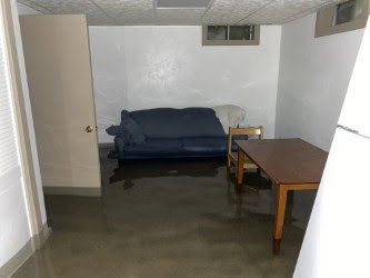 A room with standing water on the floor, indicating significant water damage requiring restoration by Flow State Restoration in Gilbert, AZ