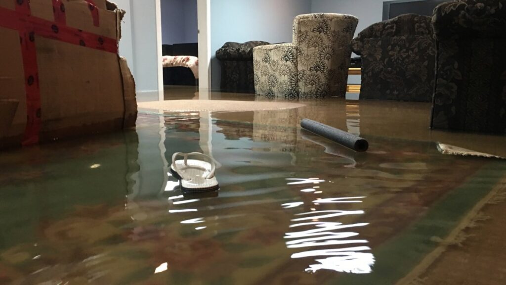 A residential room severely flooded with water, showing furniture partially submerged, handled by Specialized Cleaning & Restoration, Inc. in Bismarck, ND.