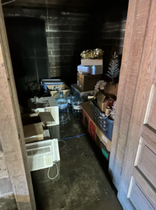 A severely flooded storage room with standing water and damaged items, ready for cleanup by USA Water Damage Thunder Restoration in Coon Rapids, MN.