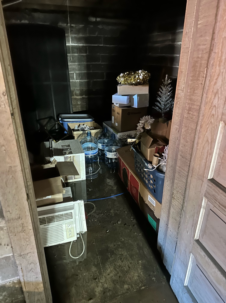 A severely flooded storage room with standing water and damaged items, ready for cleanup by USA Water Damage Thunder Restoration in Coon Rapids, MN.