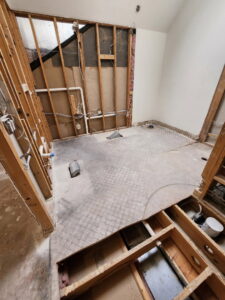 Interior room with floor partially removed and walls stripped to studs, a demolition project by Allis Demolition & Hauling LLC in Omaha, NE