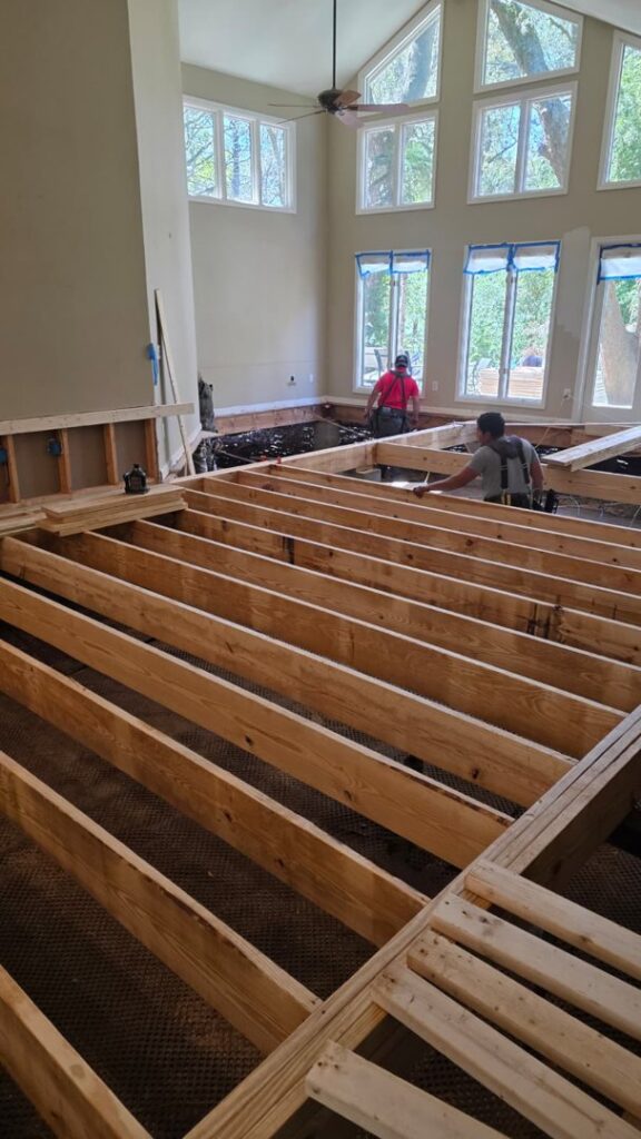 Workers replacing floor joists after significant water damage, showcasing remediation services by Coastal Site Services in Bluffton, SC.