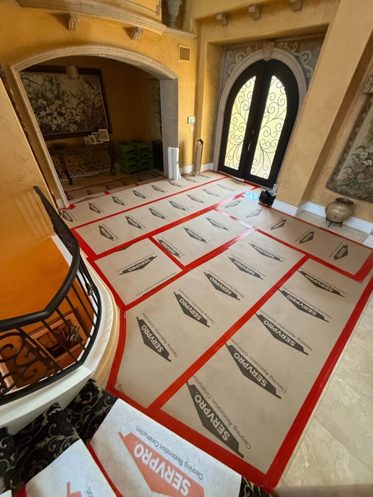 Protective floor coverings with Servpro branding installed in a grand entryway during restoration work by Servpro of Sandy in Sandy, UT.