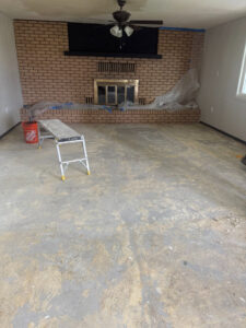A room with a stripped floor and plastic sheeting, prepared for water damage repair by Highway Renovation in Twin Falls, ID.