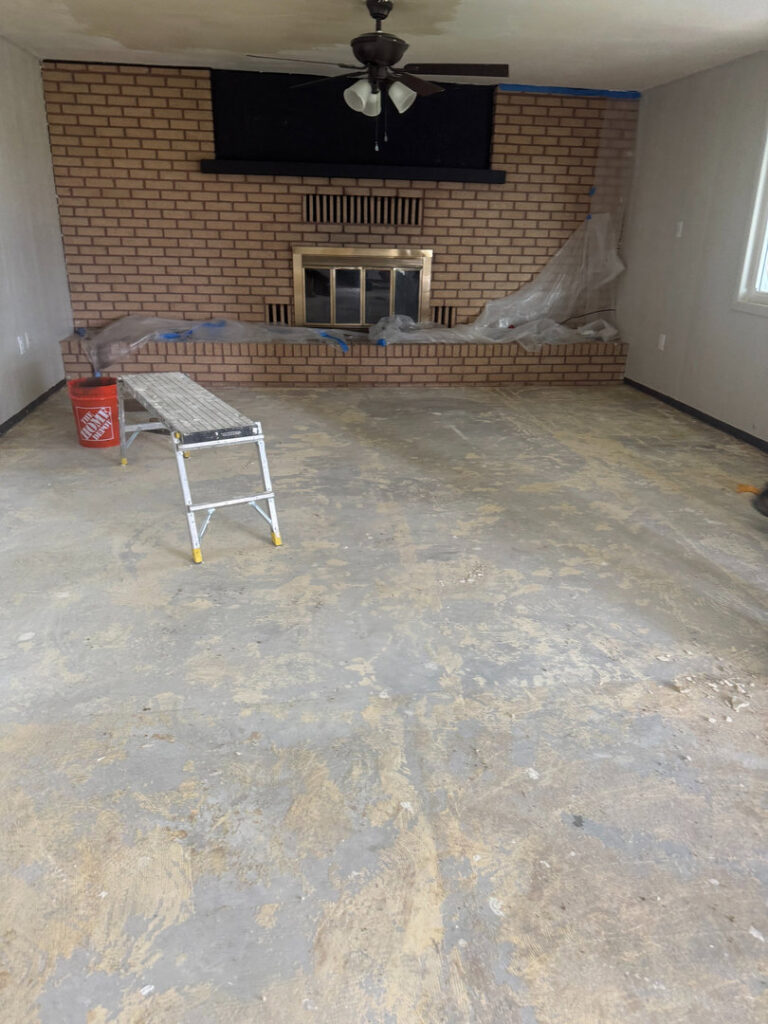 A room with a stripped floor and plastic sheeting, prepared for water damage repair by Highway Renovation in Twin Falls, ID.