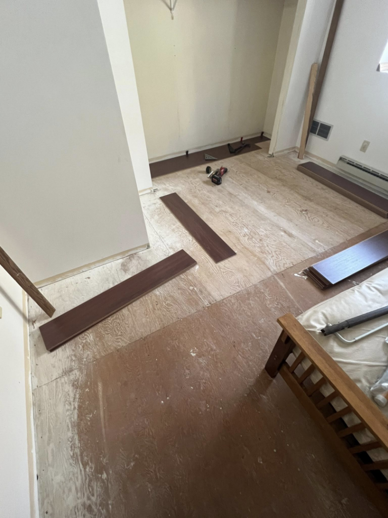 New flooring planks laid out on an exposed subfloor during water damage restoration by Agate Bay Restoration in Two Harbors, MN.