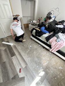 A Brothers Restoration technician installing new flooring after water damage repair in a home in Post Falls, ID.