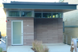 A flush panel garage door seamlessly integrated into a modern building, installed by Windsor Door Sales Inc. in Ogden, UT.