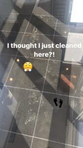 Footprints visible on a recently cleaned black tiled floor, illustrating the ongoing need for cleaning services from The Cleaning Fairy in Fort Lauderdale, FL.
