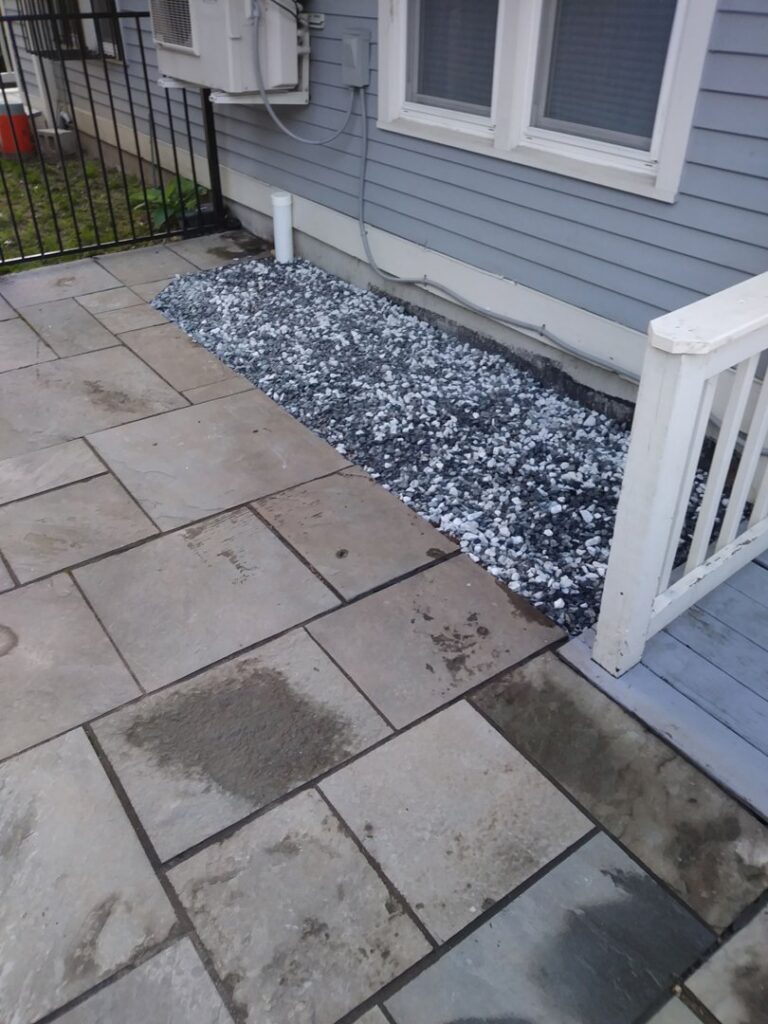 A finished foundation drainage system with a decorative gravel bed by EFFECTIVE WATERPROOFING in Worcester, MA.
