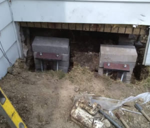 Foundation underpinning and repair work with concrete blocks and metal supports by Fort Wayne Foundation Repair Experts in Fort Wayne, IN.