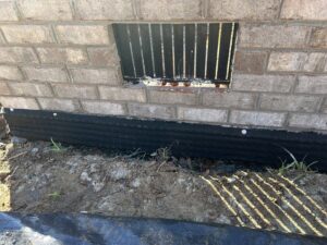 A foundation wall with a black waterproofing membrane installed by Wetlock Waterproofing in Rock Hill, SC.