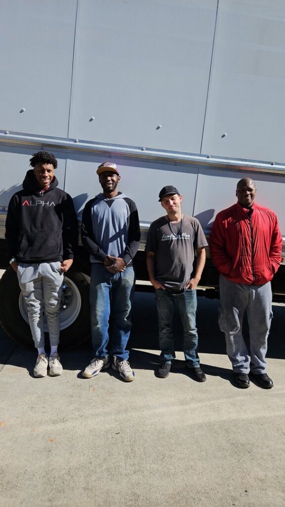 A team of four professional movers from Rambling Man Logistics standing in front of a moving truck in Hildebran, NC.
