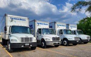 Four Top Notch Movers trucks lined up in a parking lot in Madison, WI, ready for multiple jobs.